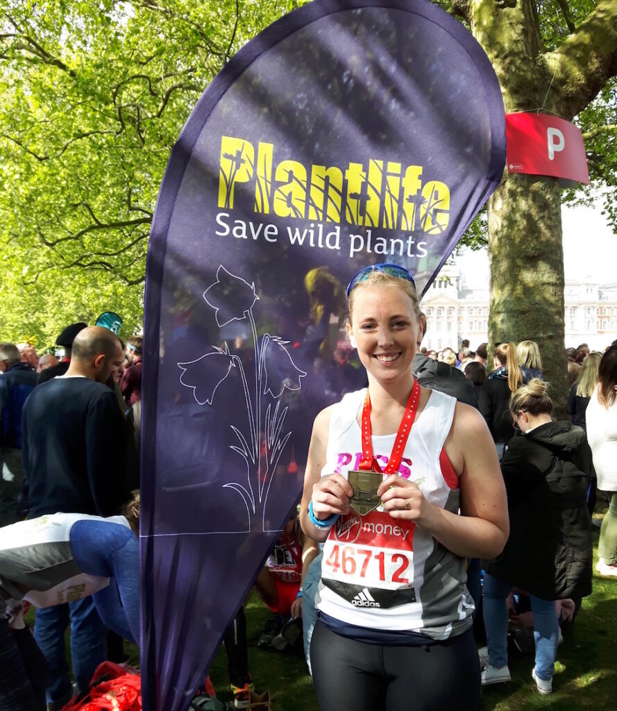 A female runner with a medal.