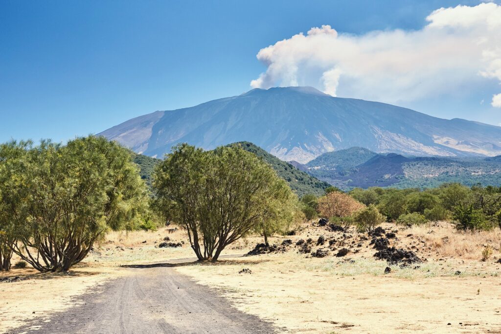 Mountain in background, with arid beachy landscpe in foreground