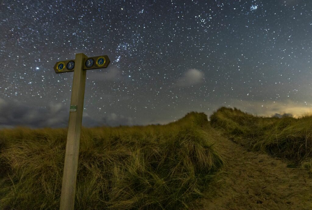 A sign on the dunes at night